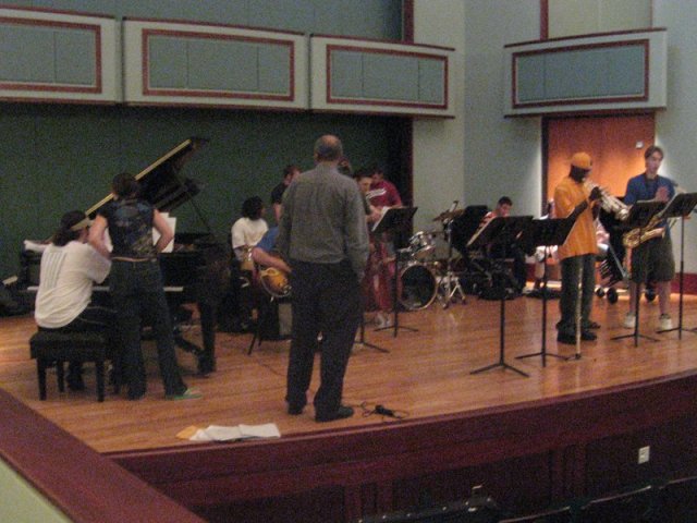 A small jazz combo practicing on a stage.